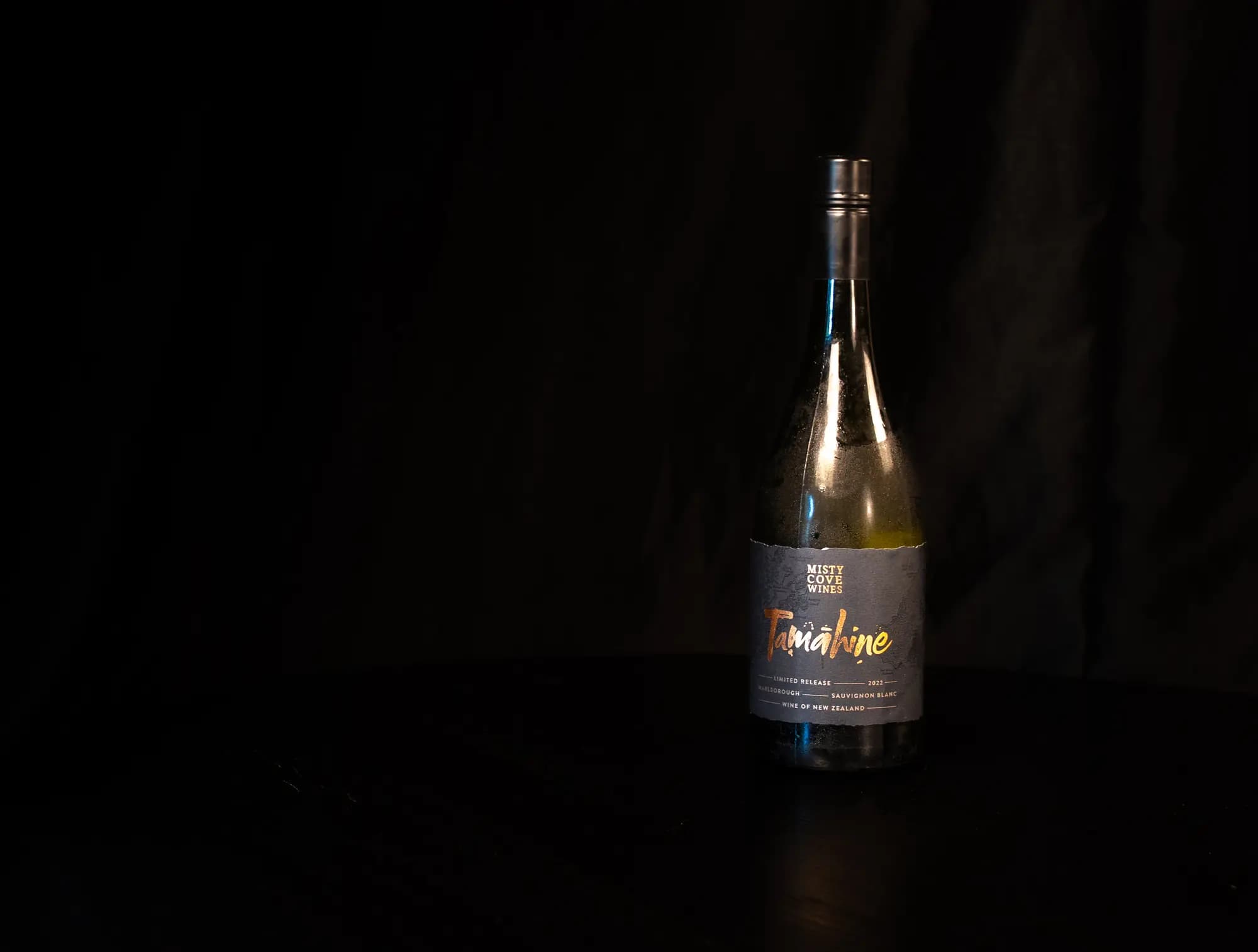 Beslagen fles Misty Cove Tamahine Sauvignon Blanc uit Nieuw-Zeeland tegen zwarte achtergrond