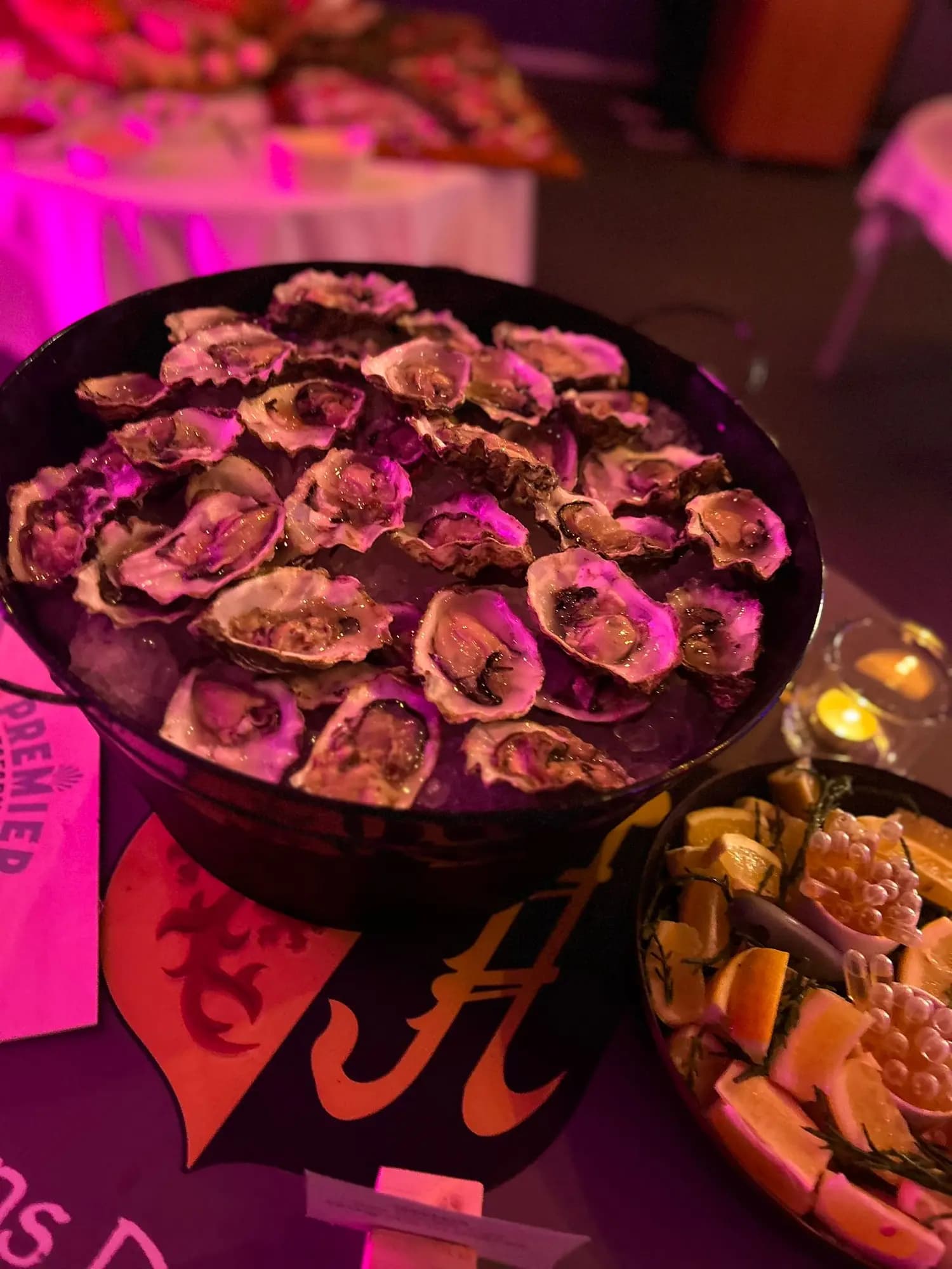 Verse oesters op ijs in een grote schaal, met citrus en garnituur ernaast